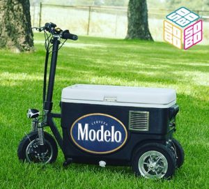 Custom Modelo scooter cooler you can ride, parked on a lawn with a big brand logo