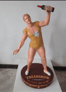 Freakshow Wines 3D resin strongman display holding a Cabernet bottle over his head