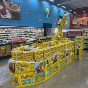 Pacifico wakeboarder display built from stacked beer cases on a grocery store floor