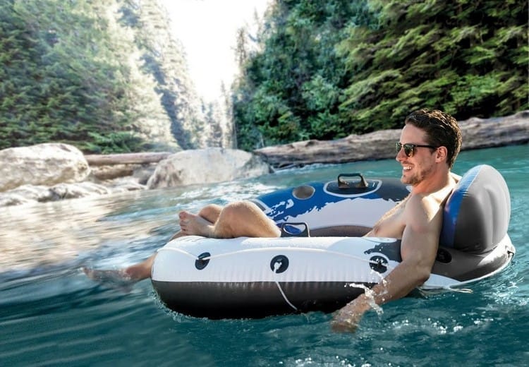 adventurous man floating on custom float heading down a river