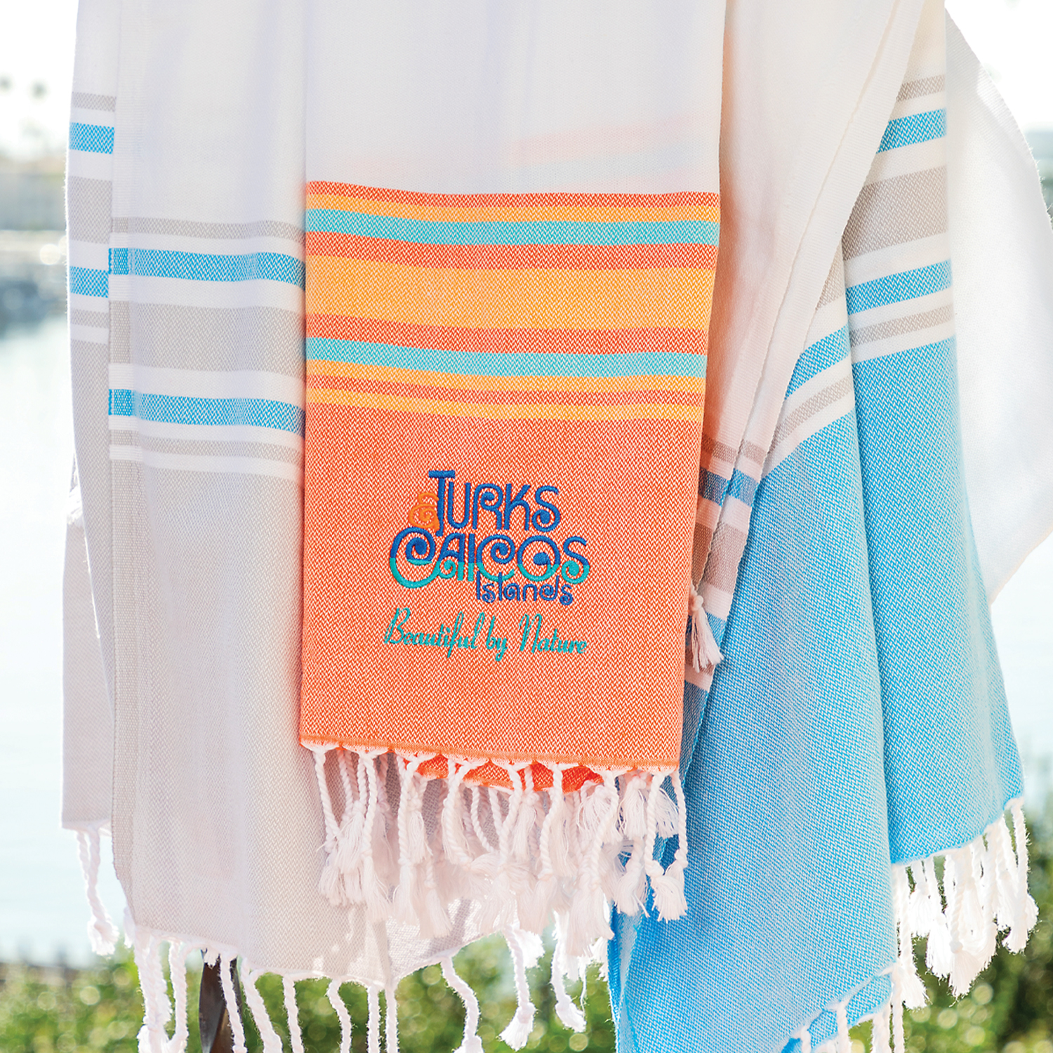 Custom branded Mediterranean peshtemal beach towel with multicolor stripe pattern and embroidered logo