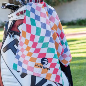 Custom golf towel in colorful waffle texture draped over golf bag