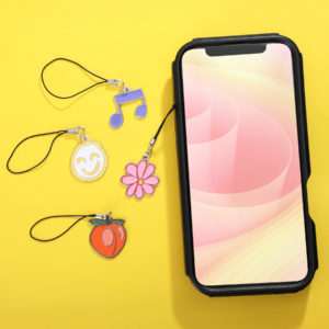Custom die struck phone charms shaped as a music note, flower, and a strawberry