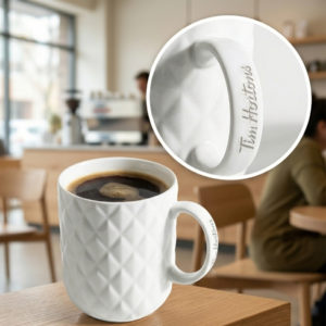 White bone china pineapple mug with coffee on a café table for employees