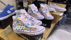 White Converse high top custom sneakers with a colorful all-over shape pattern