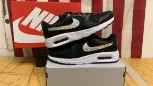Black Nike custom logo sneakers with a printed gold and silver pattern swoosh
