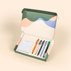 Day One Desk Kit new hire kit with five branded pens and a square tearaway notepad