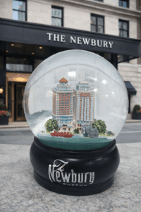 The Newbury Boston custom snow globe with the hotel scene and a black logo base